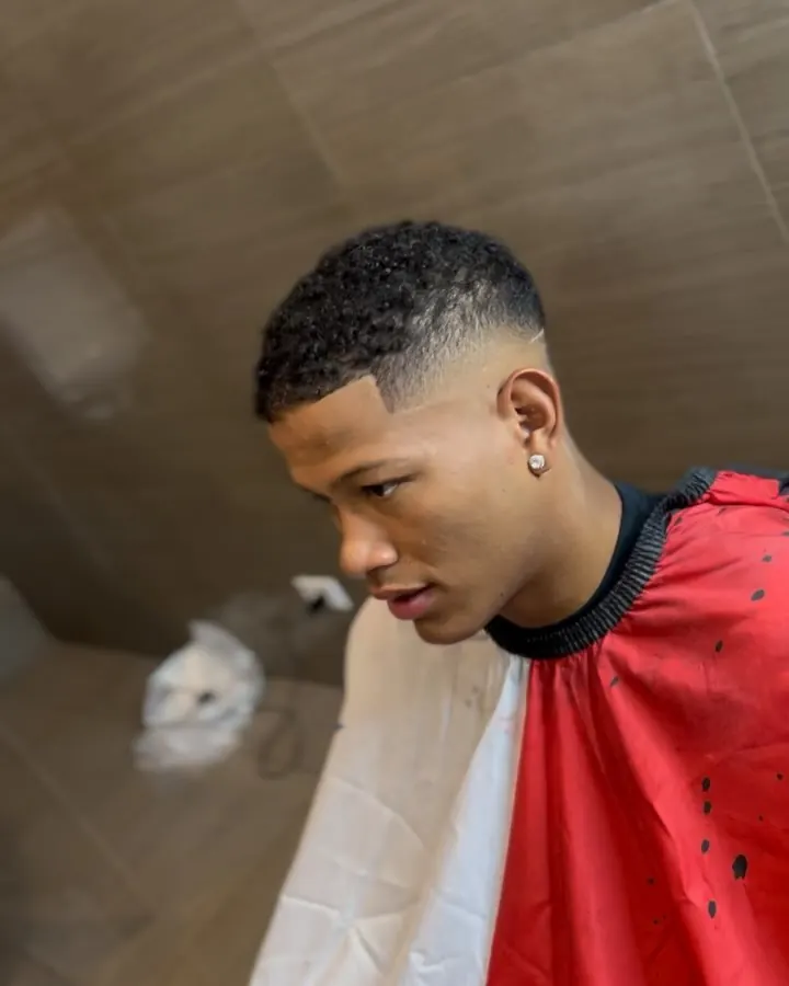 Fade alto con rizos cortos arriba