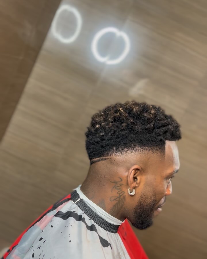 Fade bajo con rizos texturizados y linea marcada