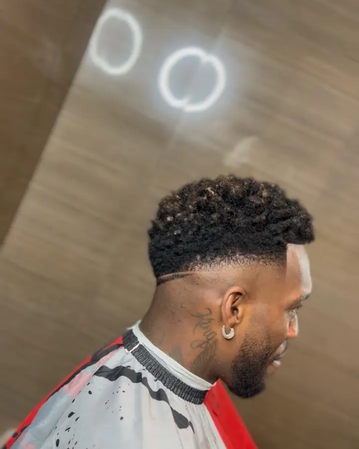 Fade bajo con rizos texturizados y línea marcada